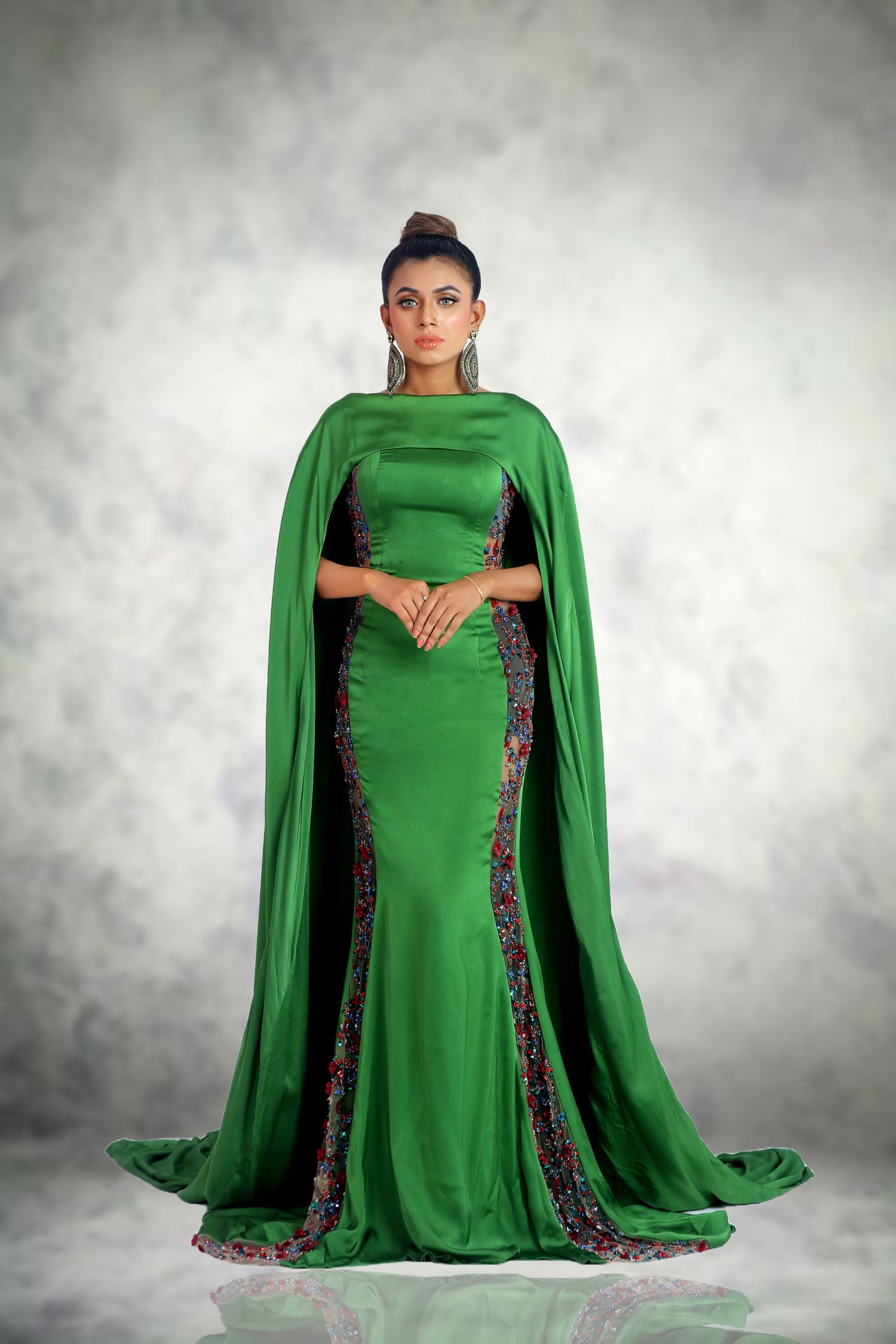 Evening Gown for Ball Event  Step into the realm of high fashion with Devon couture by Jannat Akhi, where every stitch tells a story of luxury and every seam is a testament to timeless style. Our latest creation, a green silk satin evening gown, is designed not just to turn heads but to set hearts racing and to redefine what it means to dress for a ball event. Off-Shoulder Neckline with Cape Sleeves  The gown’s off-shoulder neckline is a bold statement of modern elegance, offering a glimpse of the collarbones and shoulders, while the cape sleeves drape gracefully, adding a layer of mystique and movement. This design choice is a celebration of confidence, inviting you to showcase your poise with every step. Craftsmanship in Beadwork  Adorned with exquisite beadwork, each bead is meticulously placed by the hands of skilled artisans. The craftsmanship speaks of a dedication to artistry, with patterns that catch the light and cast a constellation of reflections, mirroring the night sky. Chic Design on Silk Satin Green Gown  The chic design of the gown is a harmony of tradition and innovation. The silk satin fabric, with its lustrous sheen, complements the contemporary silhouette, making the gown a perfect choice for those who seek to blend classic charm with modern sophistication. Siren Silhouettes, Devon Couture by Jannat Akhi  Jannat Akhi’s vision for Devon couture is clear—each gown is a journey, a narrative woven into the fabric of the design. This green gown is no exception; it’s a declaration of fashion as a form of expression, a way to tell your story without uttering a single word.