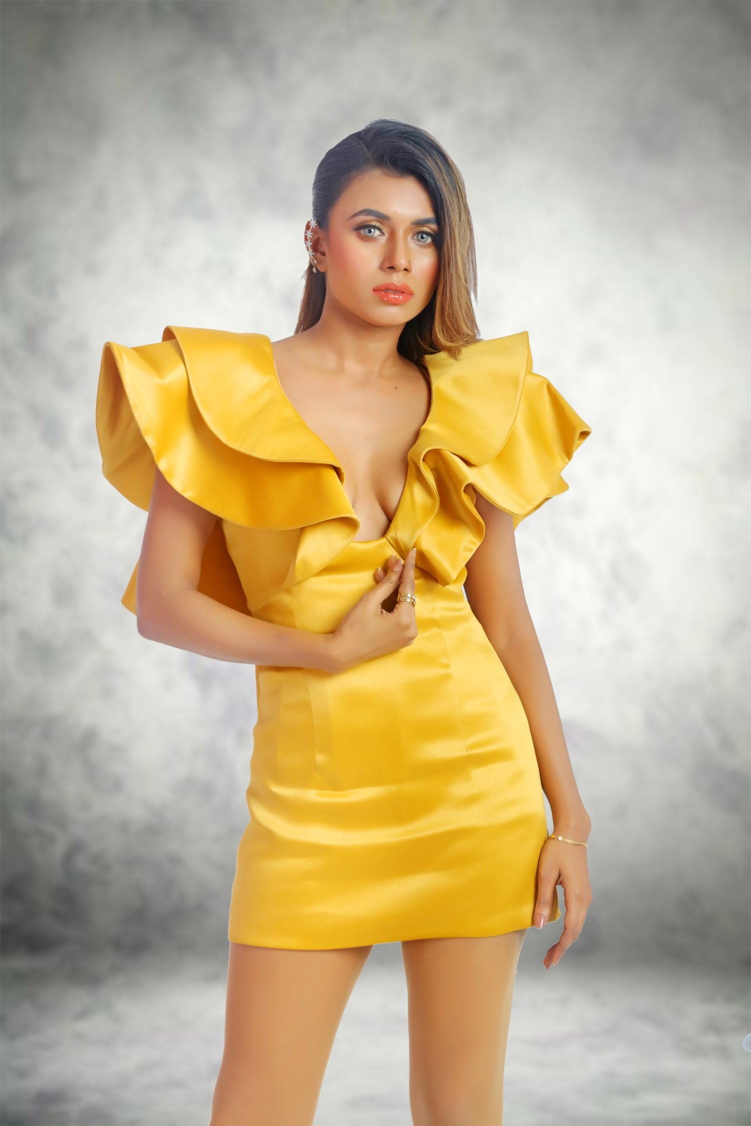 Mustard Yellow Dress  Embrace the epitome of elegance with Devon Couture’s latest ensemble, the Mustard Yellow Dress. A garment that encapsulates the essence of chic sophistication, this mini dress is a harmonious blend of contemporary style and classic charm. The mustard yellow hue is not just a color; it’s a statement of fashion-forward boldness, a nod to the avant-garde, and a tribute to the vibrant spirit of modern femininity. Spandex Lining, Seamless Fit  The Devon Couture experience is one of unparalleled comfort and seamless fit, thanks to the meticulous integration of Spandex lining. This dress contours gracefully to your form, offering a second-skin sensation that moves with you. The Spandex lining is the secret to a flawless silhouette, ensuring that every curve is caressed and every line is smooth. It’s the foundation of confidence that allows you to stride with poise and grace. Mini Dress in Taffeta Fabric  Crafted from the most exquisite Taffeta fabric, this mini dress is a masterpiece of textile artistry. The fabric’s crisp and smooth texture whispers luxury with every fiber, creating an aura of opulence that is palpable. The Taffeta, known for its lustrous sheen and sumptuous feel, transforms the dress into a canvas of splendor, reflecting a luster that rivals the golden rays of dawn. Ruffled Design, Back Zip  The ruffled design of the dress is a playful yet sophisticated element that adds a dimension of texture and movement. Each ruffle is a wave of fabric that flutters with a life of its own, imbuing the dress with a sense of whimsy and charm. The back zip is a testament to the thoughtful construction of the garment, offering a seamless closure that maintains the sleek contour of the dress while providing ease of wear. Corset Bodice Built  The corset bodice is the crowning jewel of this magnificent creation. Engineered with precision, it sculpts the torso, accentuating the natural curves and sculpting an enviable silhouette. The bodice is not just a structural element; it’s a work of art that enhances the wearer’s figure, creating a visual symphony of lines and shapes that celebrate the body in its most flattering light. Boudoir, Devon Couture by Jannat Akhi Jannat Akhi, the visionary behind Devon Couture, infuses her creations with a passion for haute couture that transcends the ordinary. Each piece is a testament to her dedication to excellence and her commitment to crafting garments that are not just worn but lived in. The Mustard Yellow Dress is a signature piece that embodies her philosophy of beauty, elegance, and enduring style.