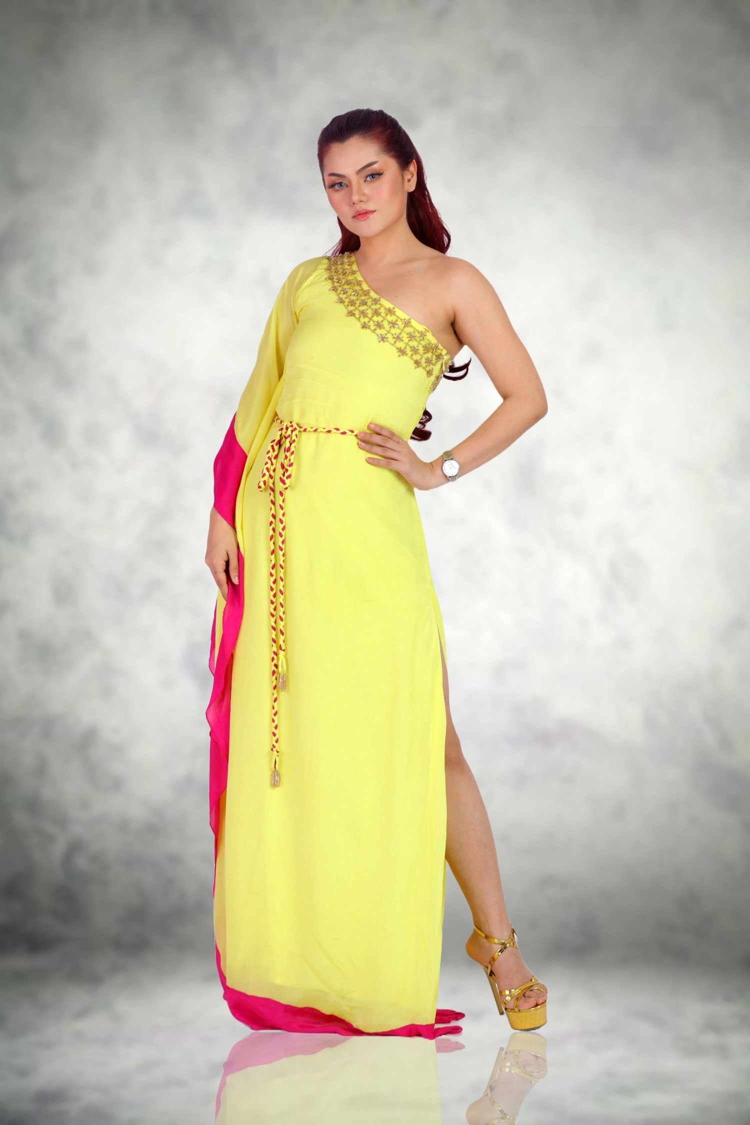 Patch Border Caftan Elevate Your Style with the Lemon Yellow Silk Georgette Patch Border Caftan Imagine a sun-drenched terrace overlooking the Mediterranean. Our Patch Border Caftan is the embodiment of summer elegance. Crafted from silk georgette, it drapes like a whisper against your skin. The lemon yellow hue is a burst of sunshine, capturing the essence of lazy afternoons. As you slip into this caftan, the world fades away – you become the epitome of effortless chic. The side slit reveals a glimpse of sun-kissed legs, a secret shared only with the breeze. This caftan isn’t just clothing; it’s an invitation to bask in luxury. Lemon Yellow with Georgette Silk The details are where magic resides. Picture the waist – cinched by a delicate waist belt adorned with micro tube beads and crystal baguettes. Each bead and crystal is a tiny constellation, shimmering against the lemon canvas. It’s not just embellishment; it’s a promise of opulence. As you fasten the belt, you step into a world where every movement sparkles. Whether you’re sipping cocktails at a rooftop bar or dancing under the stars, these details catch the light, leaving a trail of fascination. Side Slit with Zipper Closure The neckline – a daring one-shoulder silhouette – frames your collarbones. It’s a canvas for sun-kissed skin or a delicate necklace. Imagine standing by the azure sea, the caftan flowing – floor-length, pooling around your feet. The side zipper closure ensures a seamless fit, hugging your form without constraint. You’re not just wearing a caftan; you’re embodying a lifestyle – one of leisure, sophistication, and sunsets that linger. When you slip into it, you’re not just dressed; you’re adorned. Crystal Baguettes with One-Shoulder In summary, our Lemon Yellow Silk Georgette Patch Border Caftan is more than fashion; it’s an ode to sun-soaked days and moonlit nights. Waist Belt The waist belt is adorned with micro tube beads and crystal baguettes, adding a touch of opulence to the caftan. Each bead and crystal is a tiny constellation, shimmering against the lemon canvas. As you fasten the belt, you step into a world where every movement sparkles. Whether you’re sipping cocktails at a rooftop bar or dancing under the stars, these details catch the light, leaving a trail of fascination. Devon Couture by Jannat Akhi Designed by the renowned Jannat Akhi, this caftan is a testament to her exquisite craftsmanship and attention to detail. The lemon yellow hue, the delicate waist belt, and the daring one-shoulder silhouette all come together to create a piece that is both timeless and contemporary. When you wear this caftan, you’re not just wearing a piece of clothing; you’re wearing a work of art.